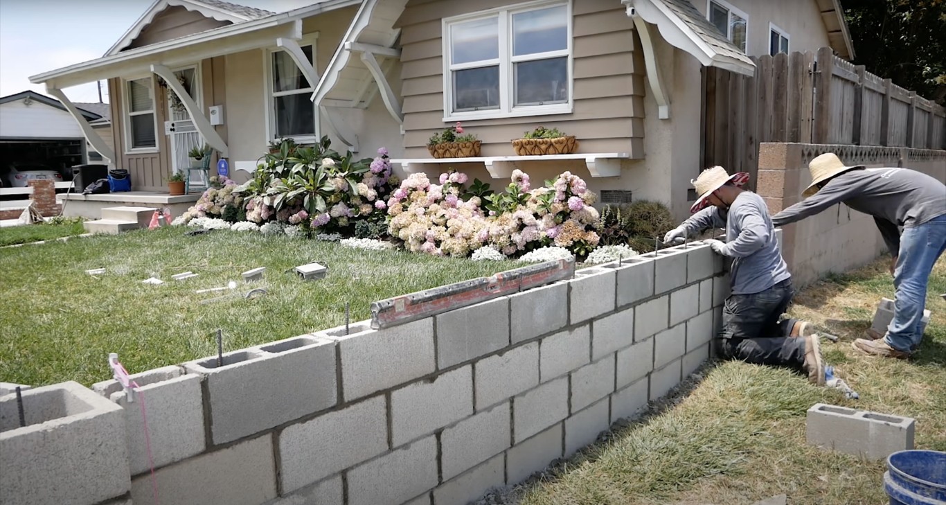 Construction of concrete block retaining wall with professional masonry techniques