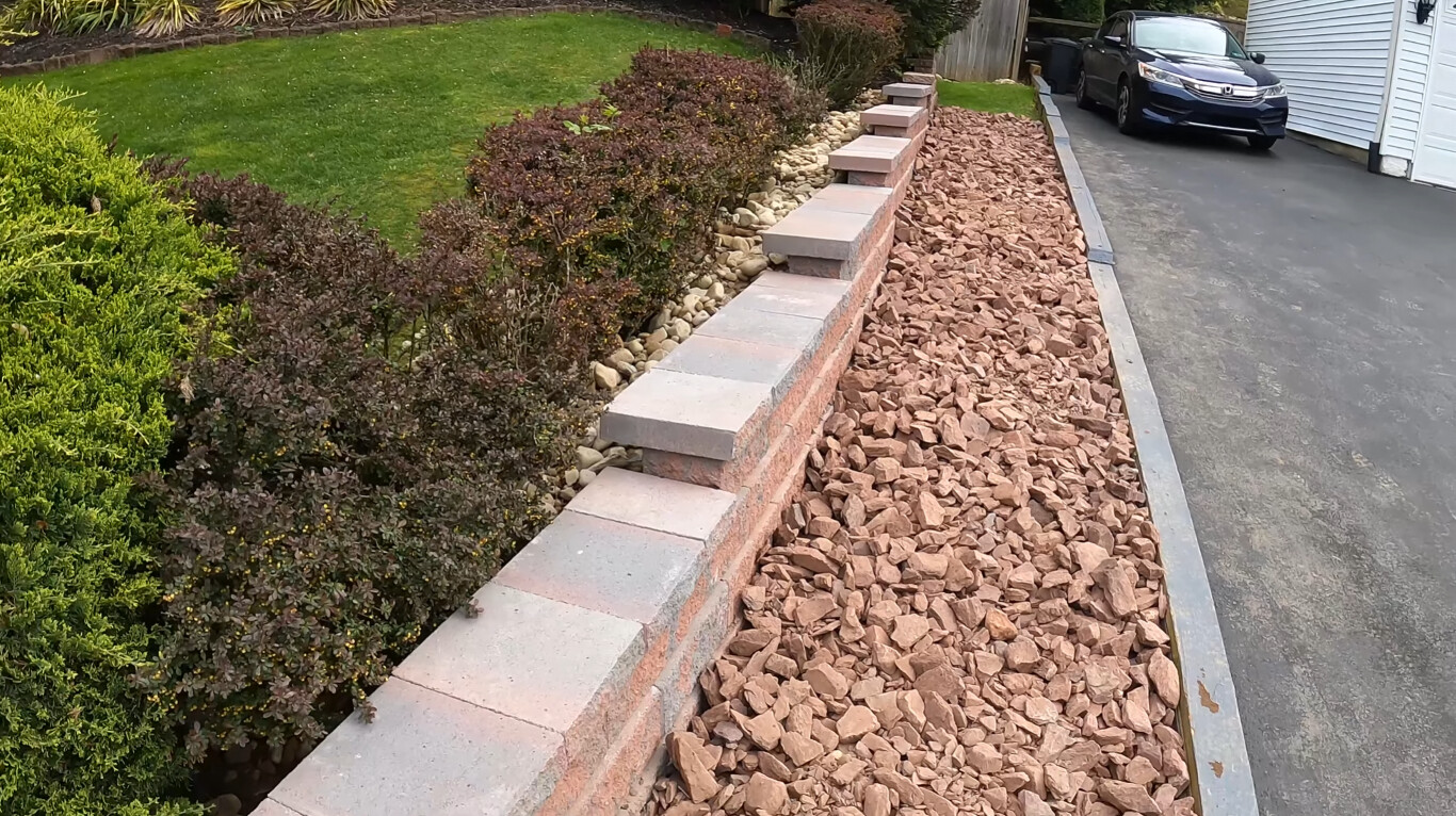 Decorative concrete retaining wall with steps and landscaping features